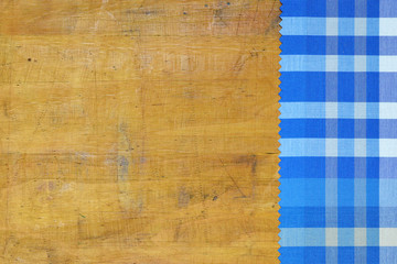 Blue checkered tablecloth on wooden background