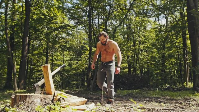 Shirtless lumberman chopping woods - super slow motion