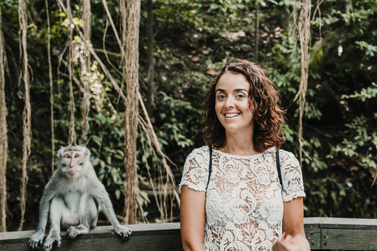 Scared funny woman taking some pictures with a cute monckey in the monckey forest in Ubud, Bali. Lifestyle. Travel photography