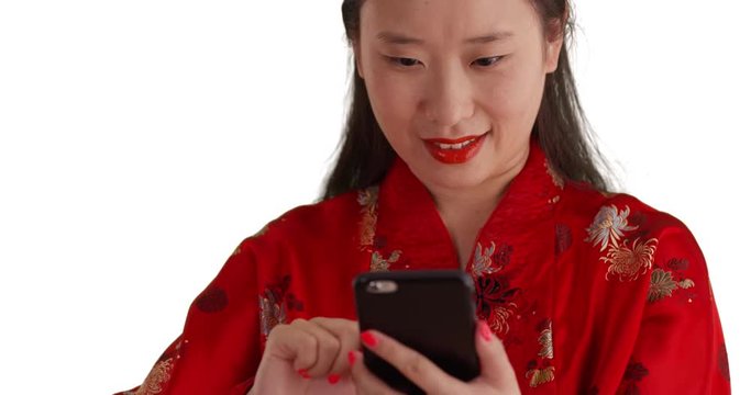 Happy Asian millennial using smart phone to read text messages for copy space, Lovely young Chinese woman wearing traditional fashion isolated on white studio backdrop, 4k