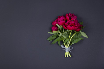Peonies flowers bouquet on dark background with copy space.