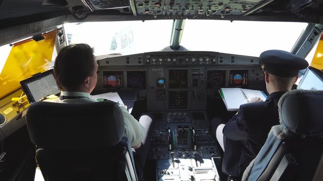 The pilot checks the aircraft for the flight.  Passenger plane on the runway. Pilots prepare the plane for takeoff. Pilots in the cockpit. Emergency landing of the aircraft. 4k