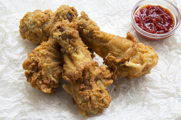 Fried chicken drumsticks with sauce , side view. Closeup.