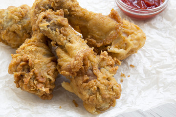 Fried chicken drumsticks with sauce , side view. Close-up.
