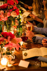 Hands eating and drinking on a decorated table at a wedding reception