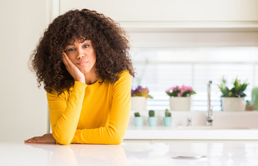 African american woman wearing yellow sweater at kitchen thinking looking tired and bored with...