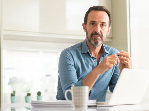 Middle Age Man Using Laptop At Home With A Confident Expression On Smart Face Thinking Serious