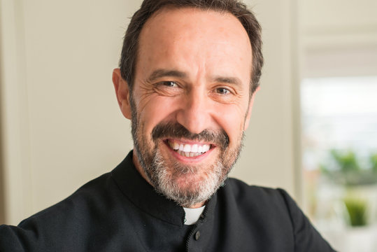 Christian priest man with a happy face standing and smiling with a confident smile showing teeth