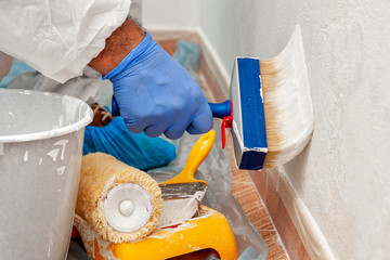 House painter at work painting a wall with a brush © francescomou
