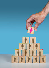 Male hand placing female leader at head of organization