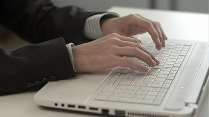 Man's hands typing on keyboard notebook