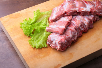 Raw Ribs on a rustic cutting board with salt, pepper and grinder for spices . copy space. Top View.