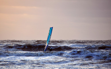 Kitesurfing against the sunset on the North sea