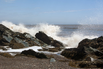 Fototapeta na wymiar Waves Crashing Against Beach Rocks