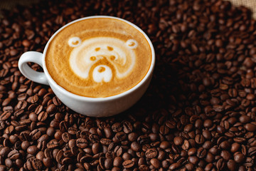 Cappuccino with a pattern on the background of coffee beans