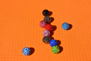 On an orange background with a structure there are chaotically beautiful multicolored balls with...