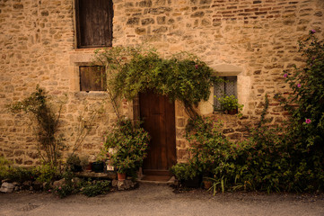 Stone Facade with Flowers  in the Alleys of the Little Medieval Village of Bruniquel