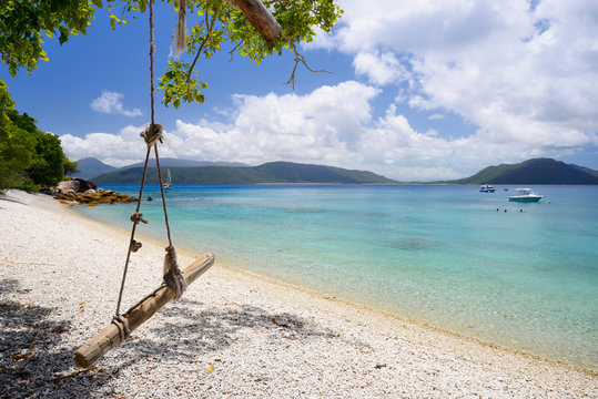 Fototapeta Wooden swing on tropical beach scene