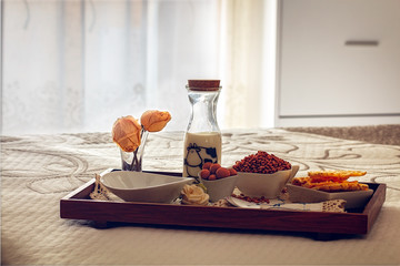 Tray with continental breakfast on hotel bed made of cereals, chocolate, cakes and a bowl with spoon. Breakfast in bed. Front view