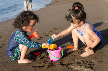 Kids at the beach playing with the sand