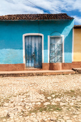 View of a cobbled street and a colorful house in Trinidad, Cuba.