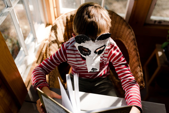 little boy reading with DIY panda bear mask