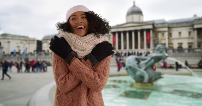 African American woman tourist trying to stay warm in chilly London weather, Black Millennial on vacation in England during winter wearing sweater and gloves, 4k