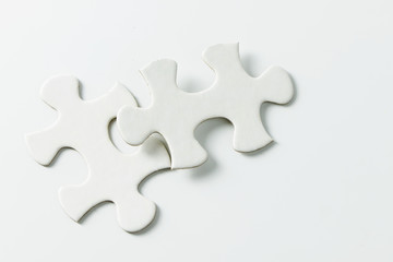 Two pieces of blank white jigsaw puzzle isolated on white background for business conceptual - obrazy, fototapety, plakaty