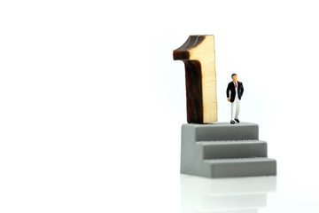 Miniature people : Businessman standing with wooden number of 1,to be the first,Business competition Concept.