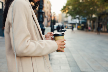 Stylish woman in the city using mobile phone.