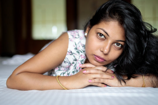 Close up portrait of beautiful young woman lying on bed