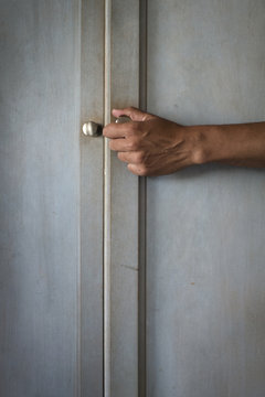 Hand opening a closet