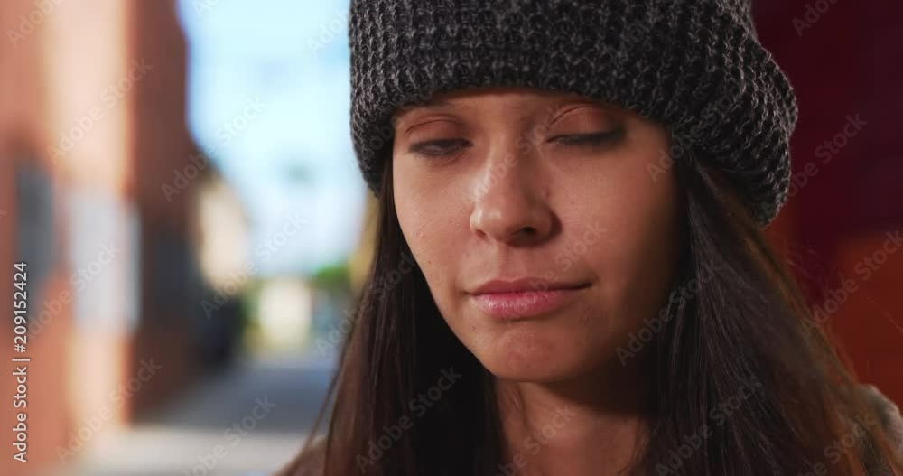 Wall mural close up portrait of millennial girl wearing beanie looking at camera in front of urban alley, tight