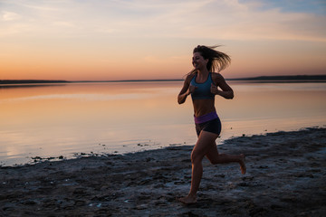 Fototapeta premium Woman Running on the Beach at Sunset.