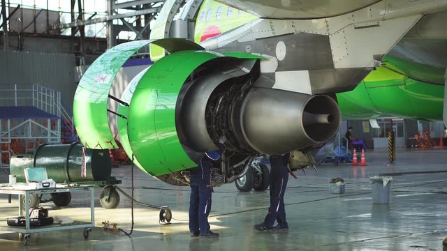 Maintenance of passenger aircraft. Engineer checks the aircraft engine. Aircraft repair in the hangar. Aircraft maintenance. Start the jet engine. 4k