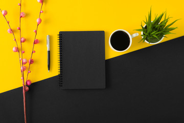 Black sketch pad with coffee cup on yellow and black background.