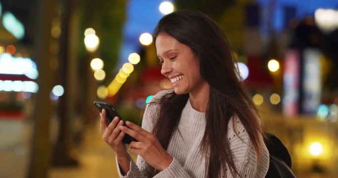 Millennial woman in grey sweater on Champs-Elysees taking selfie with mobile phone, Female backpacker takes travel photo while on Paris street at night, 4k