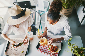 two friends eating healthy vegan food at restaurant together - obrazy, fototapety, plakaty