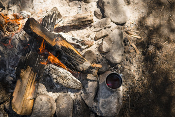 Metal mug near the fire in the camp.