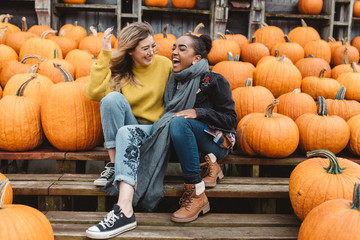 Two best friends in their twenties at a pumpkin patch