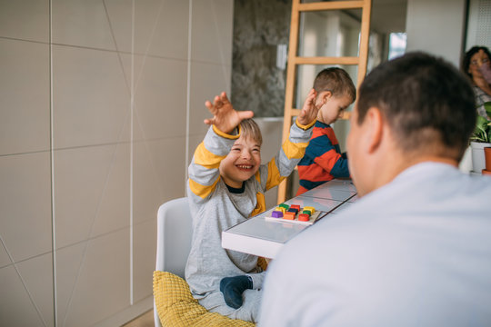Smiling boy playing with his father at table