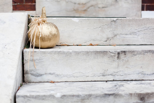 Gold decorative pumpkin on marble steps
