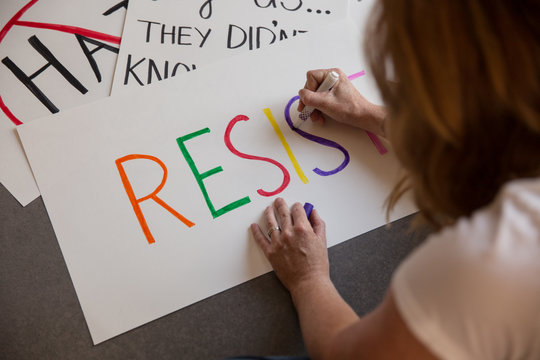 Woman making protest signs.