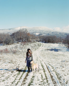 Woman with dog on snowy field