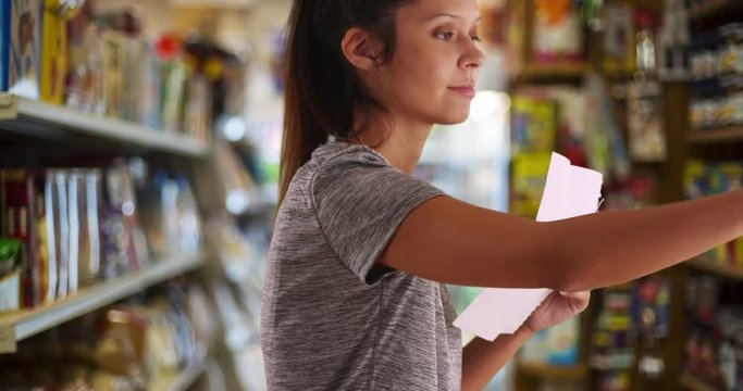 Close-up of female customer in supermarket moving items on shelf, Young woman with shopping list choosing food for purchase, 4k