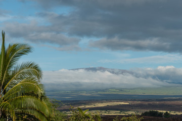 Dramatic sky over the Kohala coast on the Big Island of Hawaii at sunset with Mauna Kea peak in the background