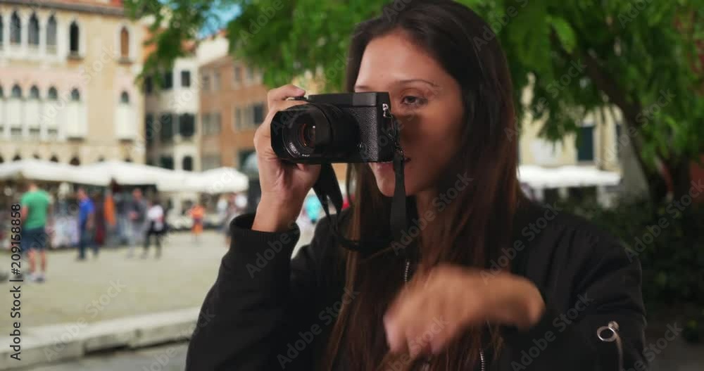 Wall mural close up of millennial woman taking photograph while on venice street on vacation, happy traveler in