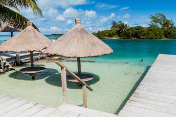 Table and a parasol in a water at Caye Caulker island, Belize