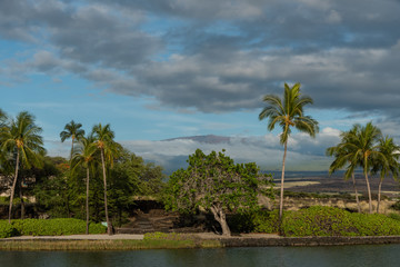 Fototapeta na wymiar Dramatic sky over the Kohala coast on the Big Island of Hawaii at sunset with Mauna Kea peak in the background