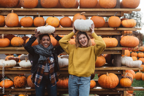 Two best friends in their twenties at a pumpkin patch